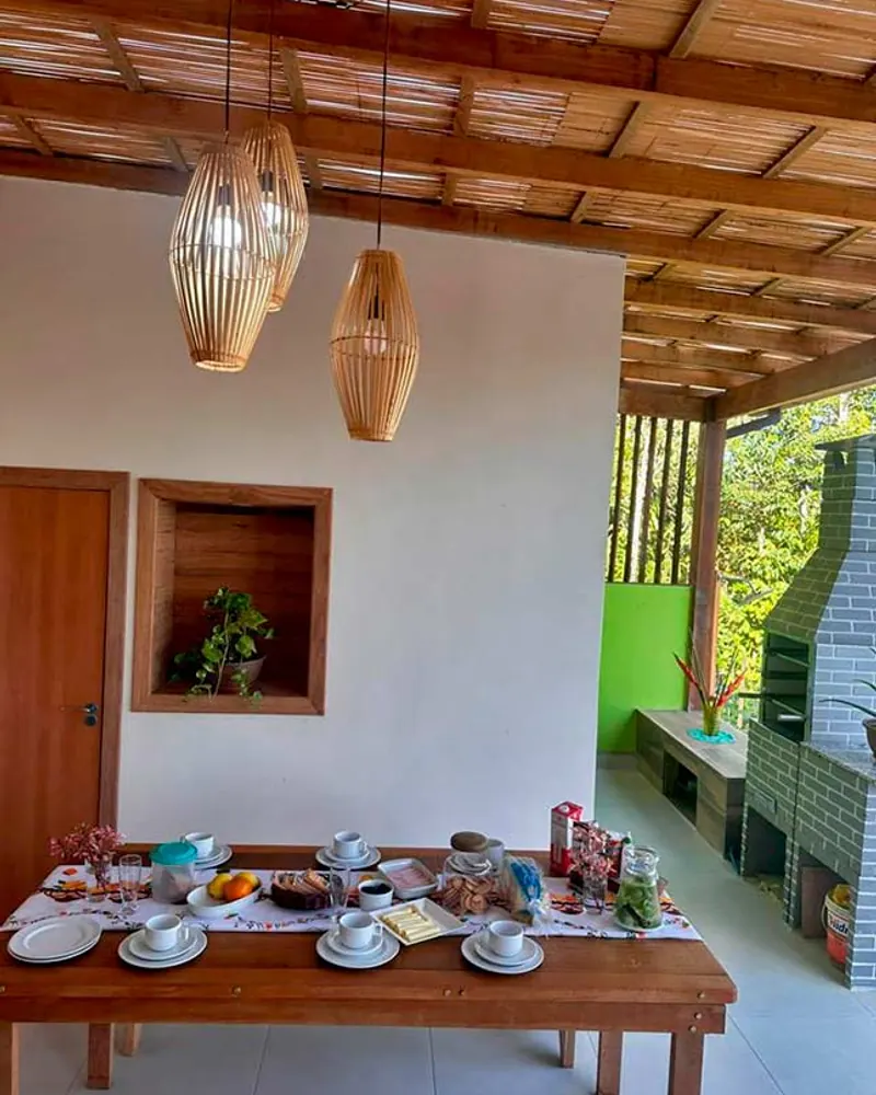 Mesa posta e churrasqueira na varanda gourmet da Casa Verde