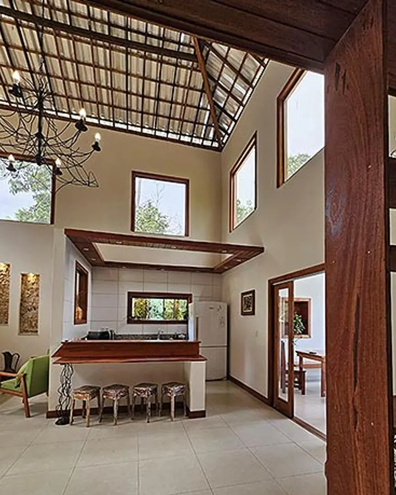 Sala integrada com pé-direito alto e estrutura de madeira
