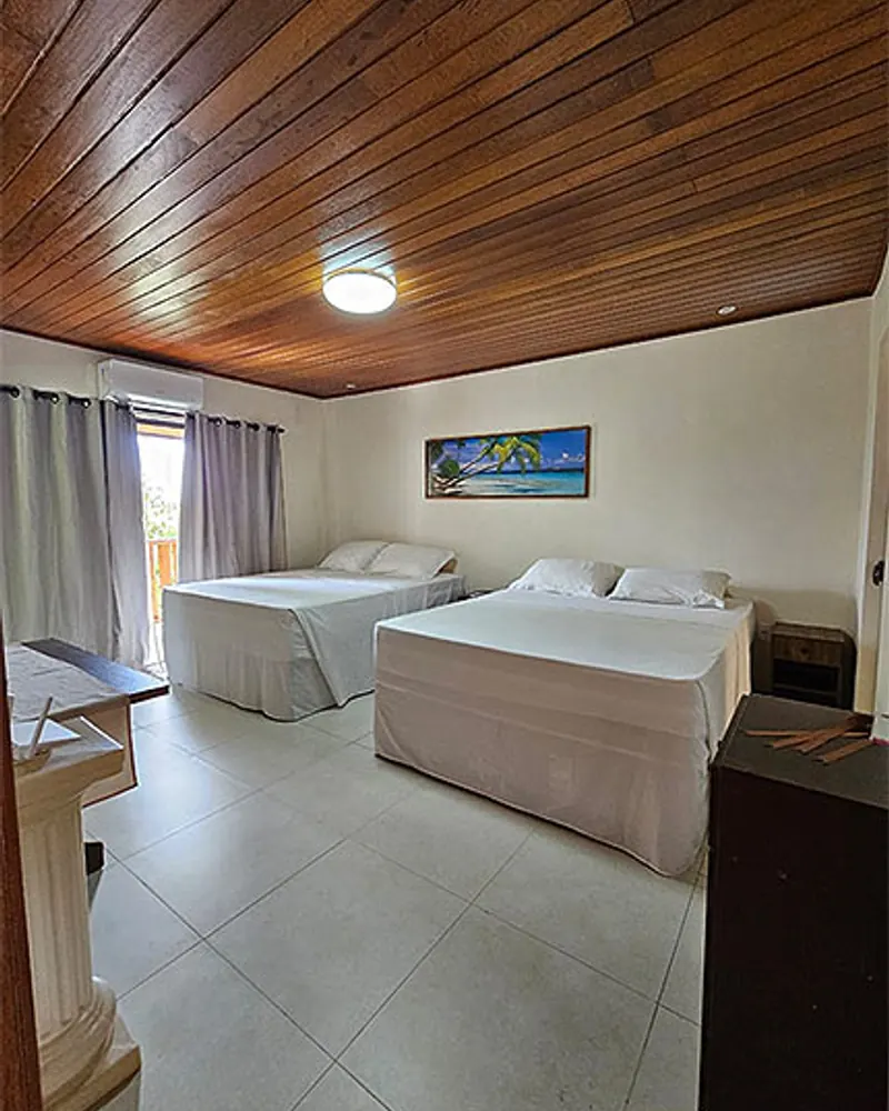 Uma das suítes da Casa Verde, com camas e teto de madeira